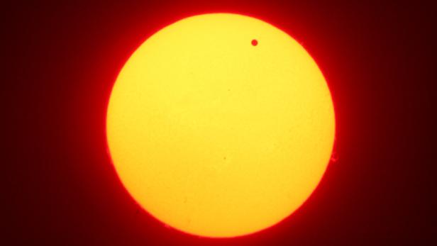 Die Venus ist als kleiner schwarzer Punkt vor der Sonne zu sehen.