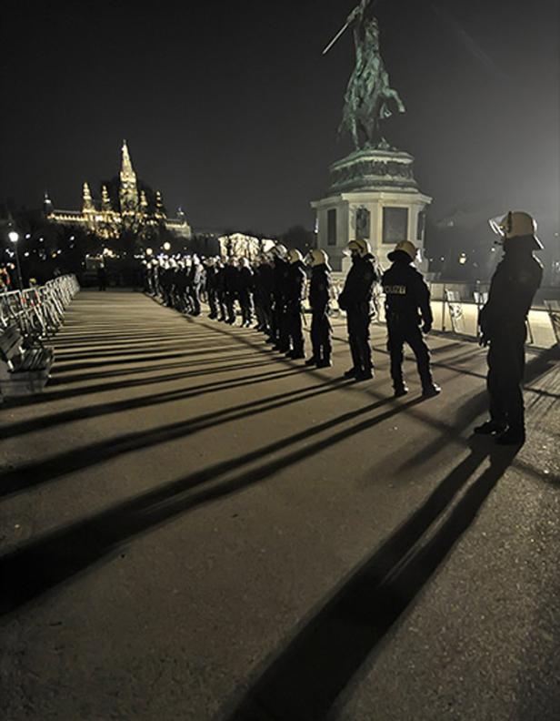 Eine Reihe von Polizisten steht nachts vor dem Burgtheater in Wien.