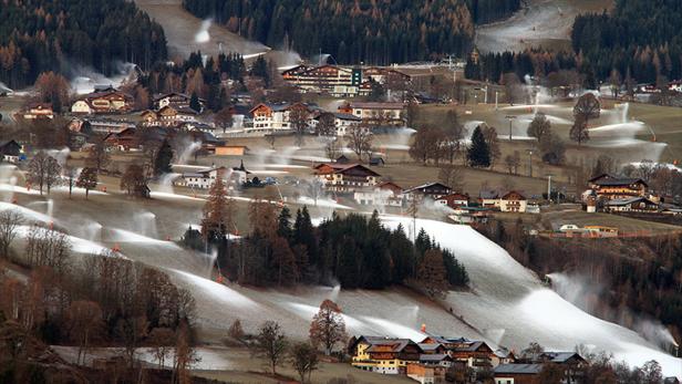 Schnee wird in einem Dorf auf Skipisten mit Schneekanonen erzeugt.