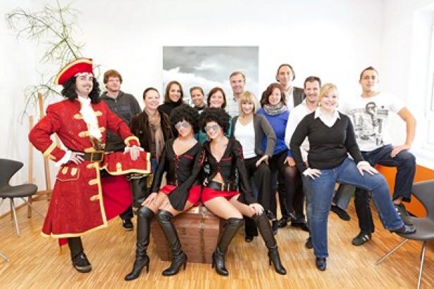 Eine Gruppe von Menschen, einige davon in Kostümen, posiert für ein Gruppenfoto.