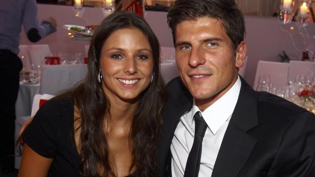 Ein Mann im Anzug und eine Frau lächeln in die Kamera.