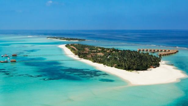 Luftaufnahme einer tropischen Insel mit weißen Sandstränden und türkisfarbenem Wasser.