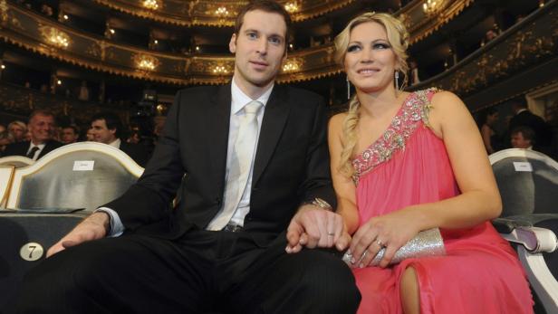 Ein Mann im Anzug und eine Frau in einem rosa Kleid sitzen in einem Theater.