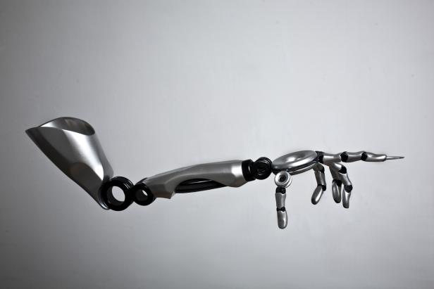 Ein silberner Roboterarm mit einer Hand, die nach rechts zeigt.