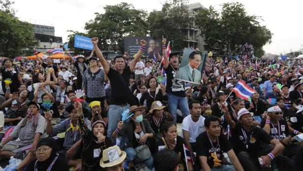 Eine große Menschenmenge demonstriert mit thailändischen Flaggen und Bildern des Königs.