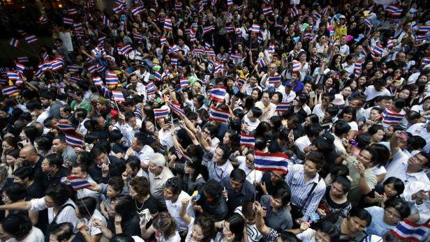Eine große Menschenmenge schwenkt thailändische Flaggen.