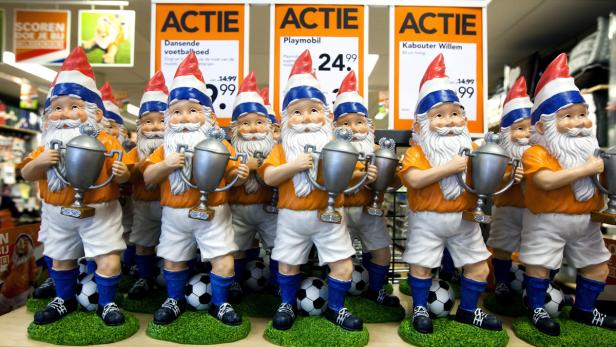 Eine Reihe von Gartenzwergen im Fußballtrikot mit Pokalen stehen zum Verkauf.