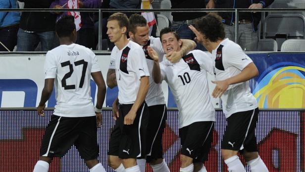 Österreichische Fußballspieler feiern gemeinsam auf dem Spielfeld.