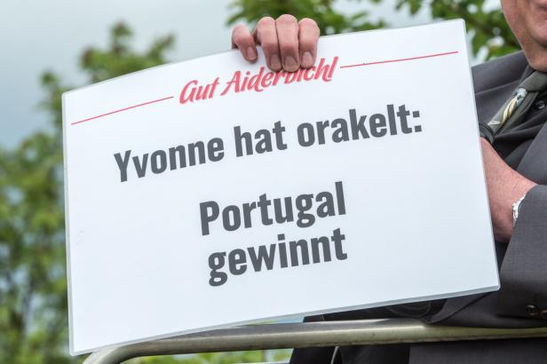 Eine Person hält ein Schild mit der Aufschrift: „Yvonne hat orakelt: Portugal gewinnt.“.