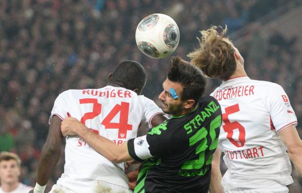 Drei Fußballspieler kämpfen um einen Ball in der Luft.