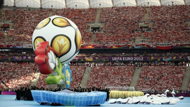 Eine Eröffnungszeremonie der UEFA Euro 2012 mit einem riesigen aufblasbaren Fußball vor einer Zuschauermenge.