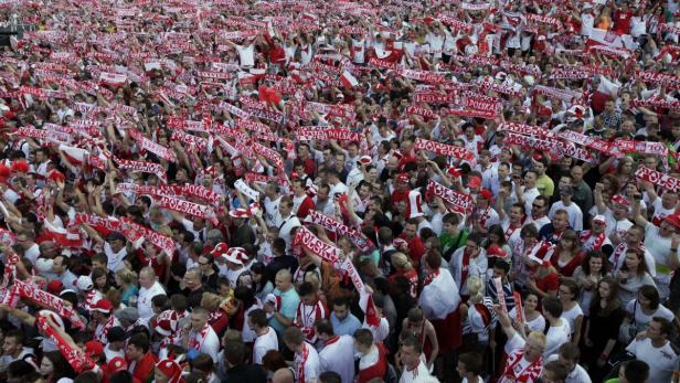 Eine große Menschenmenge jubelt mit rot-weißen Schals und Fahnen für Polen.