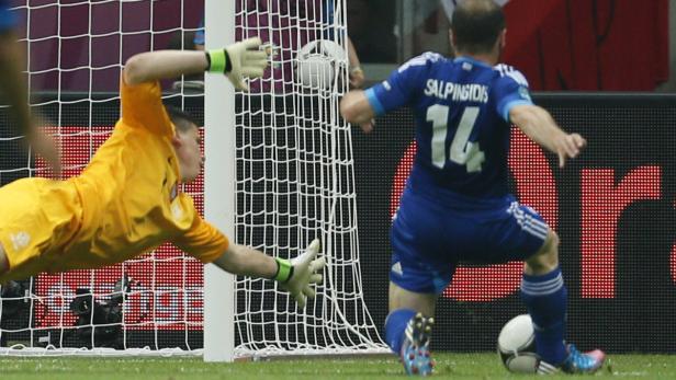 Ein Torwart in Gelb versucht, einen Schuss von Salpingidis (Nr. 14) abzuwehren.