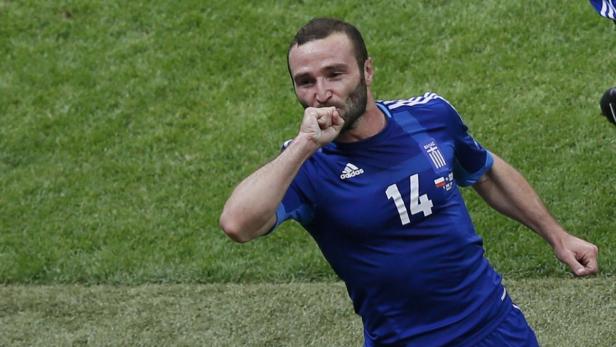 Ein griechischer Fußballspieler jubelt auf dem Rasen.