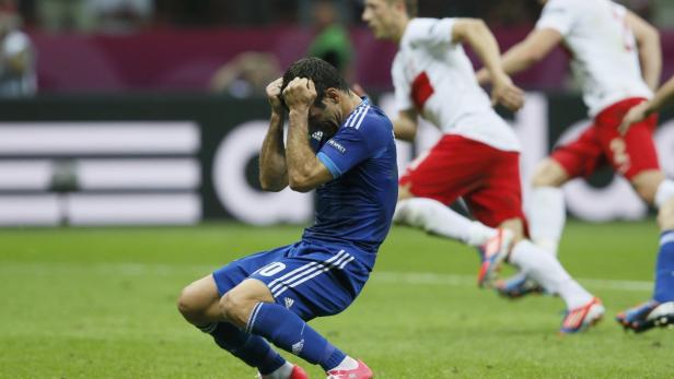 Ein Fußballspieler in blauem Trikot verzweifelt auf dem Rasen.