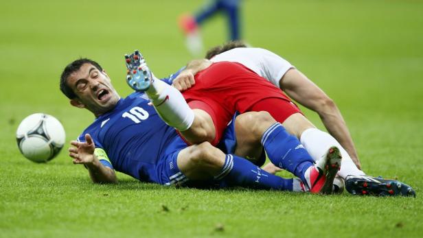 Zwei Fußballspieler kämpfen auf dem Rasen um den Ball.