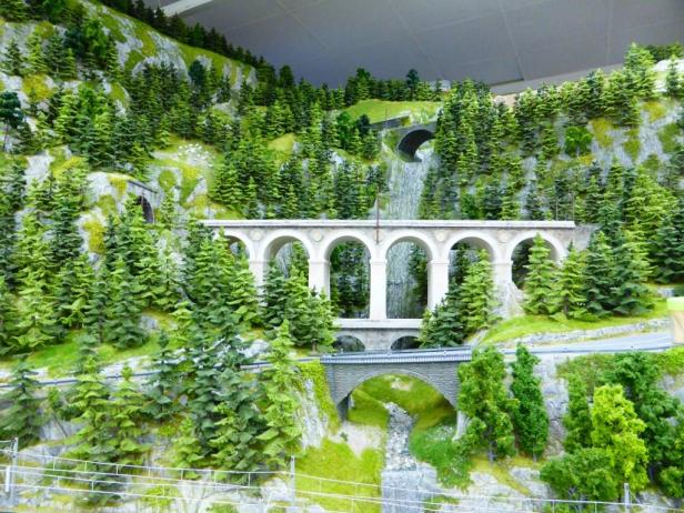 Eine Miniaturlandschaft mit zwei Brücken und vielen grünen Bäumen.