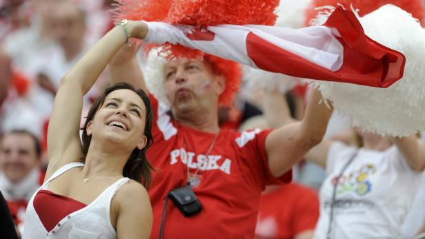 Fröhliche polnische Fans feiern mit Fahne und Pompons.