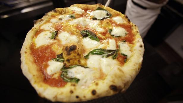 Eine frisch zubereitete Pizza Margherita mit Basilikum und Mozzarella.