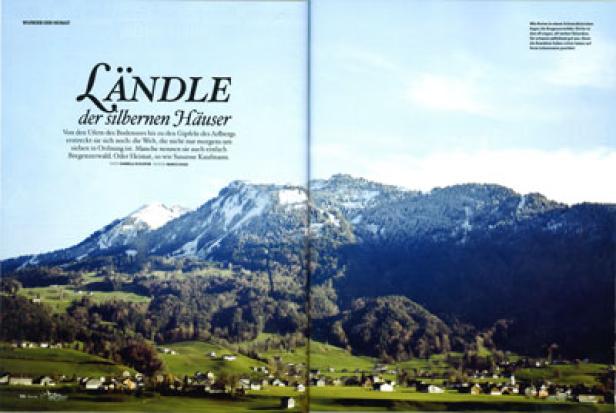 Eine Landschaft mit Bergen, grünen Wiesen und kleinen Häusern im Tal.