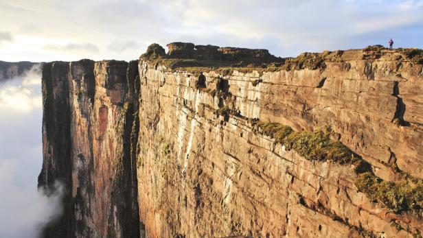 Blick auf den Tafelberg Roraima mit steilen Klippen und einer Person am Rand.