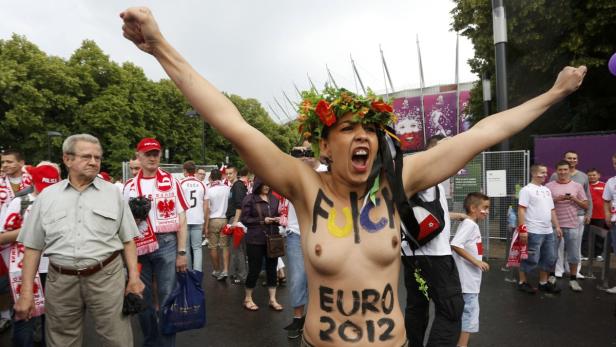 Eine Frau mit Blumenkranz und aufgemalter Aufschrift „EURO 2012“ jubelt bei einer Sportveranstaltung.