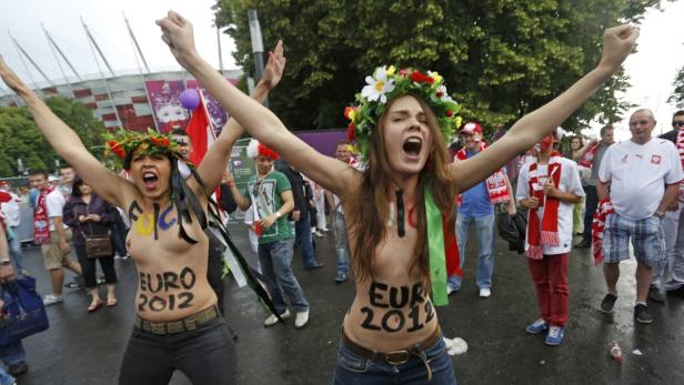 Zwei Frauen mit Blumenkränzen und aufgemalten Flaggen feiern die EURO 2012.