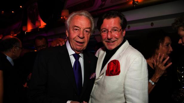 Zwei Männer posieren auf einer Veranstaltung für ein Foto.