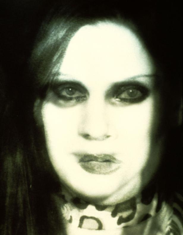 Porträt einer Frau mit dunklem Make-up und einem gemusterten Schal.