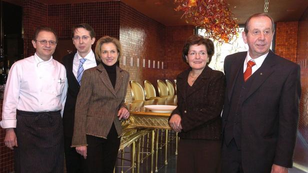Eine Gruppe von Personen steht in einem eleganten Restaurant.