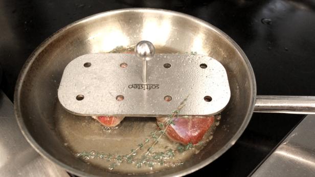 Fleisch wird in einer Pfanne mit einem Garbeschleuniger von Softisteo gebraten.