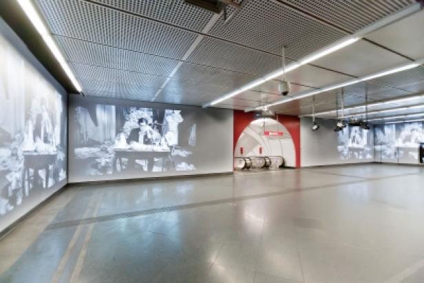 Eine U-Bahn-Station mit großformatigen Schwarzweißfotografien an den Wänden.