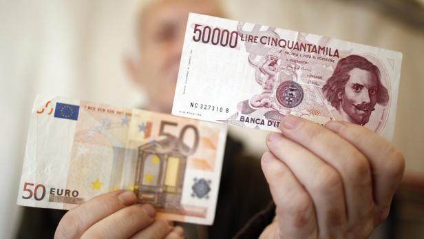 Eine Hand hält eine 50.000 Lire Banknote und einen 50 Euro Schein.