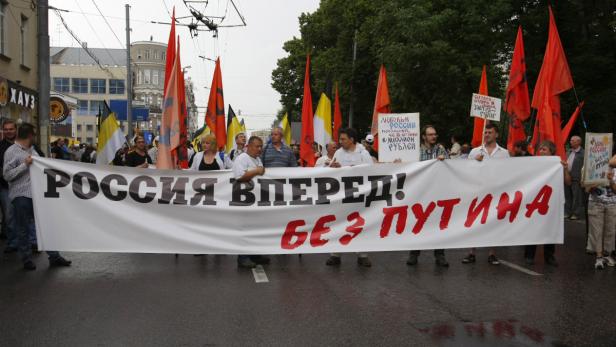 Eine Demonstration mit einer Gruppe von Menschen, die ein Banner mit der Aufschrift „Russland vorwärts! Ohne Putin“ tragen.