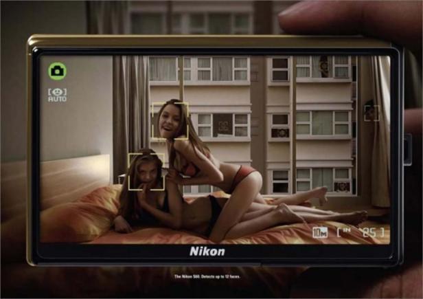 Zwei Frauen liegen in Unterwäsche auf einem Bett, aufgenommen mit einer Nikon-Kamera.