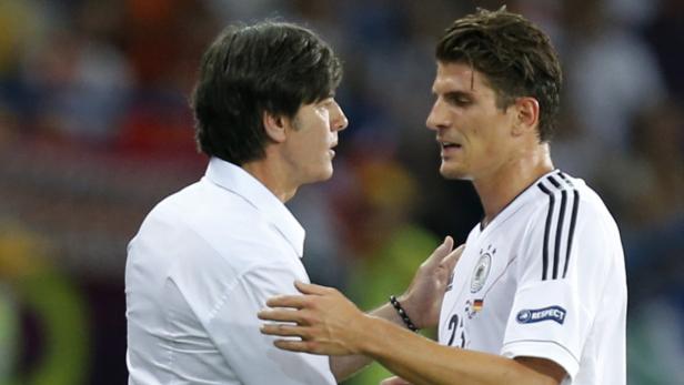 Joachim Löw spricht mit einem Spieler der deutschen Nationalmannschaft.