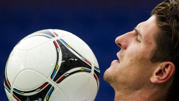 Ein Mann balanciert einen Fußball mit dem Kopf.