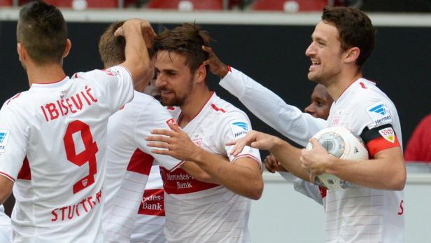 Fußballspieler des VfB Stuttgart feiern gemeinsam auf dem Platz.