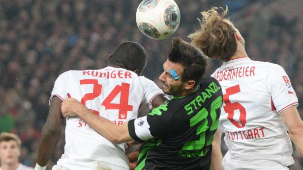 Drei Fußballspieler kämpfen um einen Ball in der Luft.