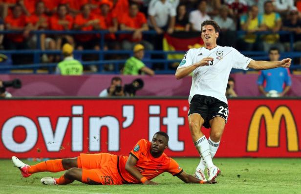 Ein deutscher Fußballspieler im Duell mit einem niederländischen Spieler.
