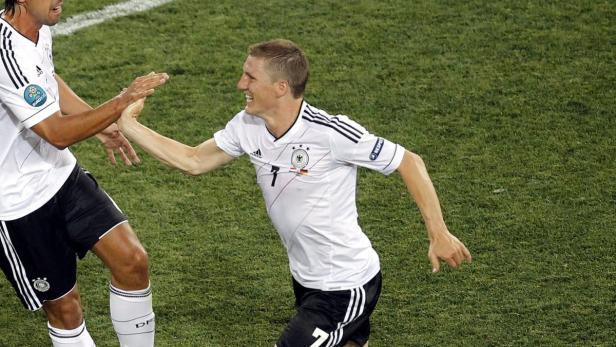 Bastian Schweinsteiger jubelt mit einem Teamkollegen auf dem Fußballfeld.