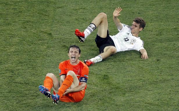 Zwei Fußballspieler liegen nach einem Spiel auf dem Rasen.