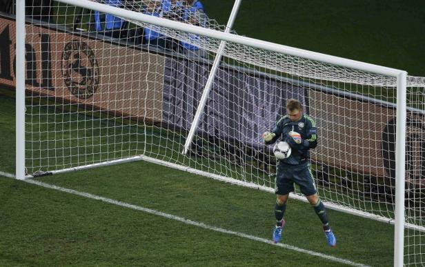Ein Torwart hält einen Fußball in einem Fußballtor.