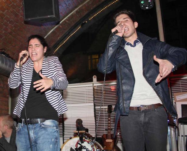 Eine Frau und ein Mann singen auf einer Bühne in Mikrofone.