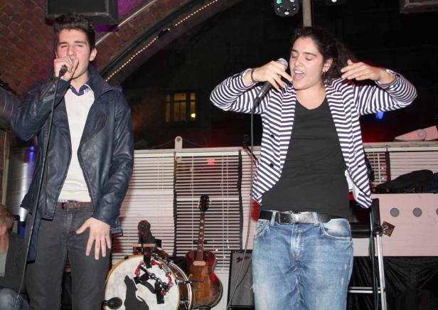 Ein Mann und eine Frau singen auf einer Bühne in Mikrofone.