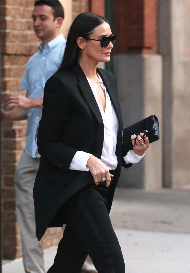 Demi Moore trägt einen schwarzen Hosenanzug und eine Sonnenbrille.