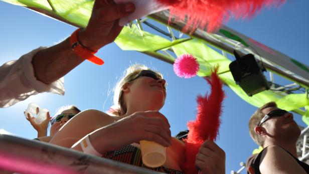 Menschen feiern auf einem Wagen mit bunten Dekorationen und guter Stimmung.