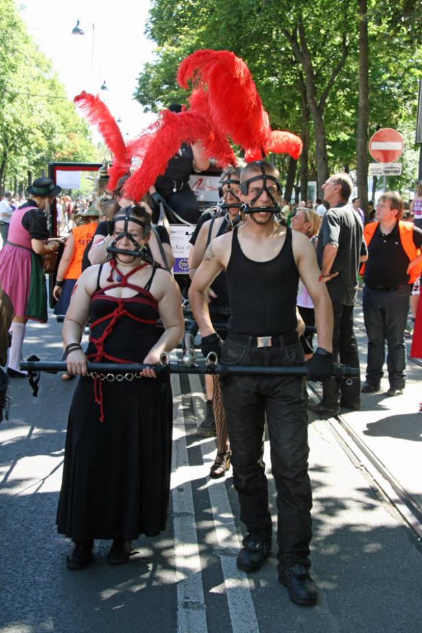Menschen nehmen an einer Parade mit BDSM-Elementen teil.