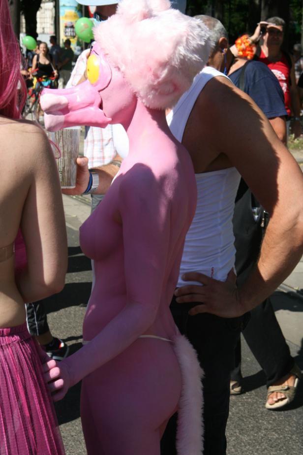 Eine Person in rosa Farbe und einem Kostüm des rosaroten Panthers auf einer Parade.