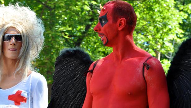 Ein Mann als Teufel mit Flügeln und eine Person als Krankenschwester verkleidet.